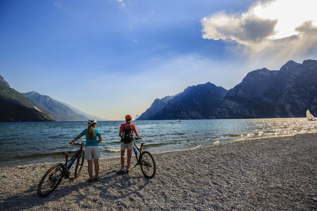 Mountain,Biking,Woman,And,Young,Girl,Over,Lake,Garda.