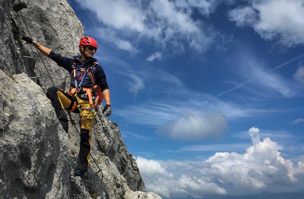 Young,Man,Climbing,On,A,Rock,In,Swiss,Alps,-