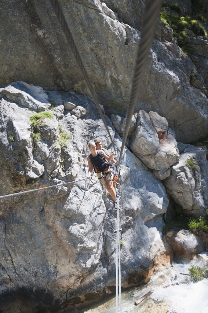 Austria,,Steiermark,,Ramsau,,Silberkarklamm,,Young,Couple,Walking,On,Rope,,Looking