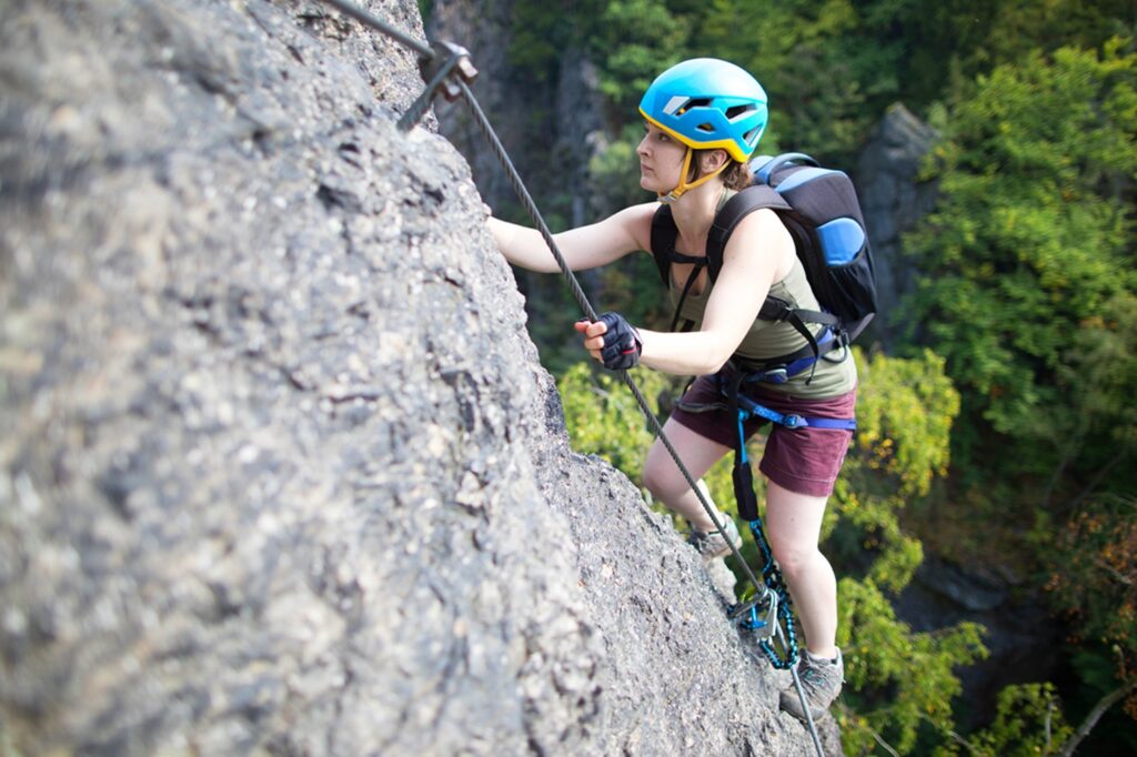 Young,Woman,Climbing,On,Rock,,Via,Ferrata,,Climber