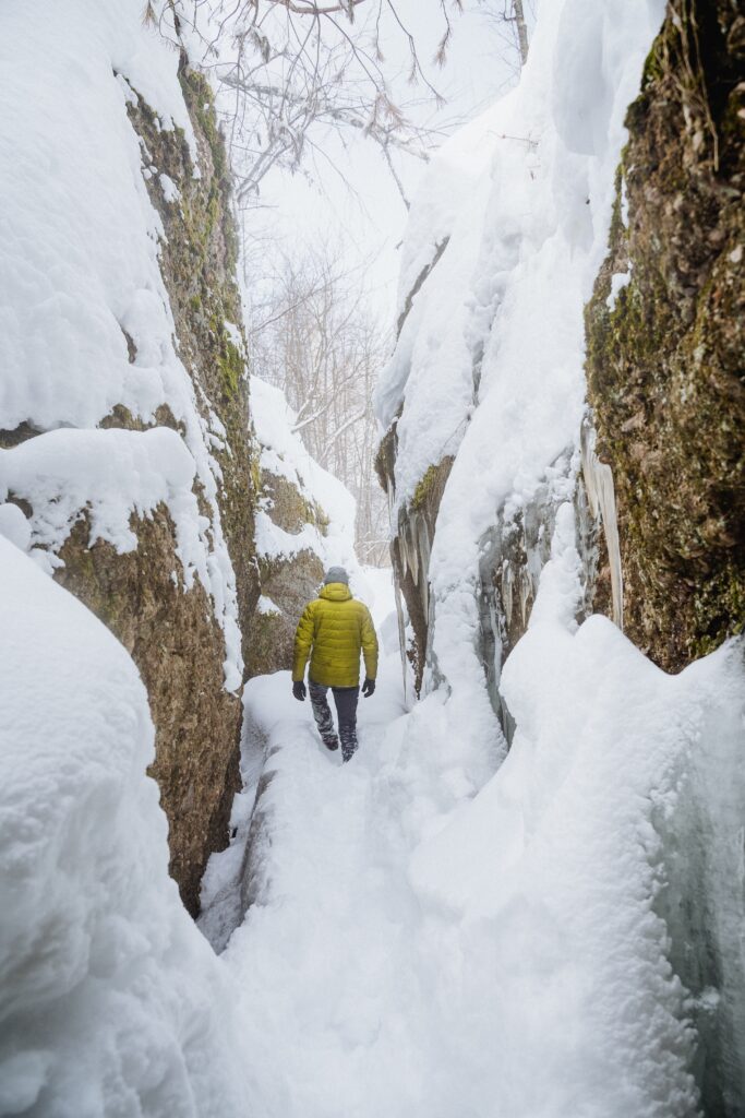 Man,Walking,On,Snow,Among,Rocks,,Trekking,In,Winter,,Hiking