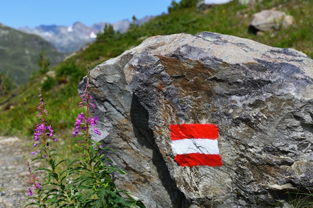 Alpine,Hiking,Trail,In,Austria,,Marked,With,Painted,Austrian,Flag
